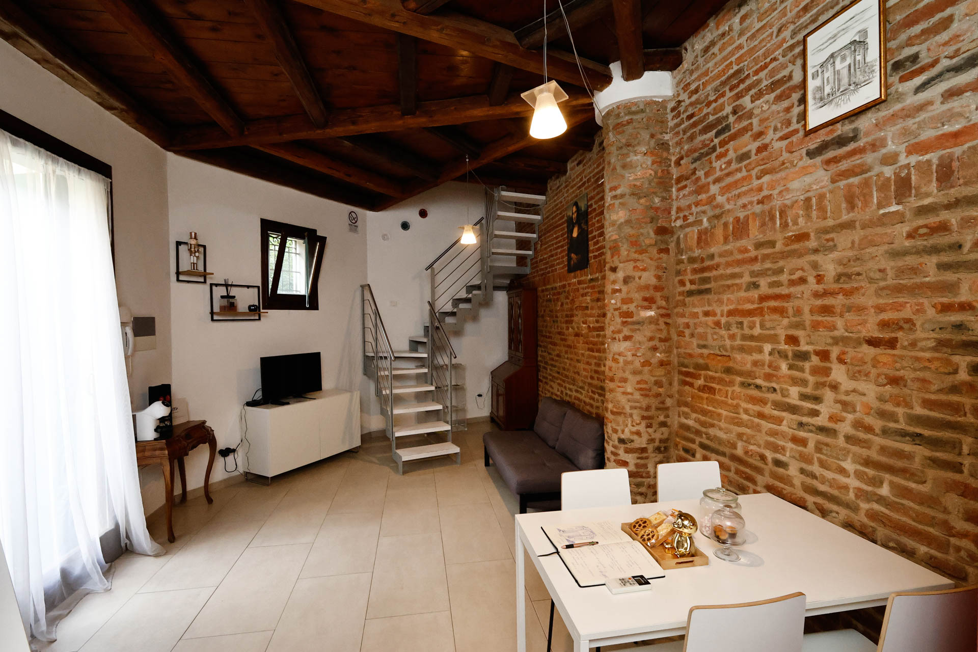 veduta dalla scala piano terra chiesetta abside con tavolo da pranzo e salotto