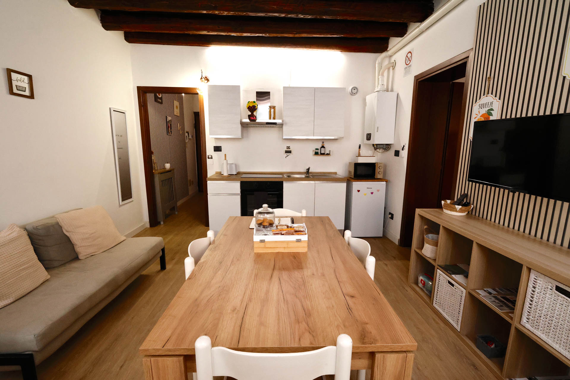 _R4A8800 soggiorno e sala da pranzo e angolo cottura wood 32, con tavolo da pranzo, televisione a muro, caldaia, piano cottura con forno incassato, forno microonde, divano